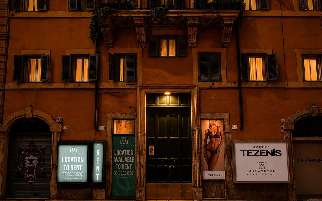 Ingresso di Más Boutique Hotel Rome di sera, su Via del Corso, con illuminazione boutique calda e dettagli architettonici